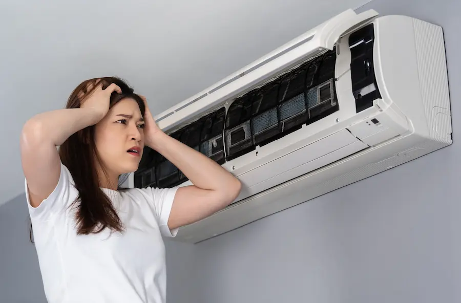 Stressed woman facing problems with her AC unit interpreting ac noises